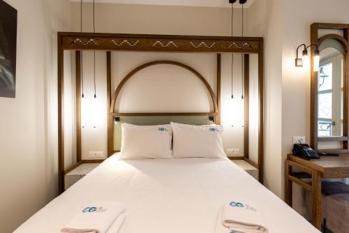 a bedroom with a large bed with two white pillows at El Greco Hotel in Chania Town
