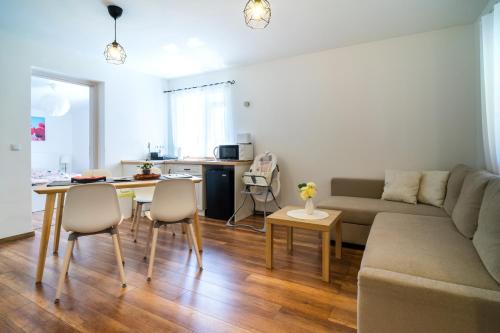 ein Wohnzimmer mit einem Sofa und einem Tisch in der Unterkunft Pipacs Apartmanház in Harkány