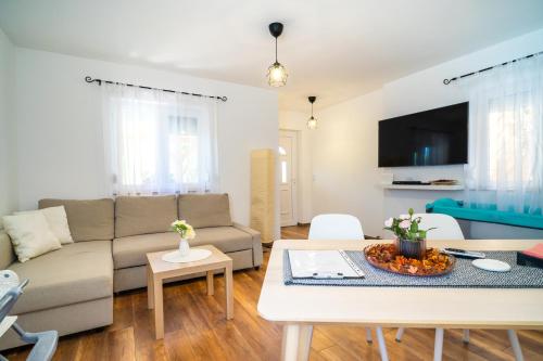 ein Wohnzimmer mit einem Sofa und einem Tisch in der Unterkunft Pipacs Apartmanház in Harkány