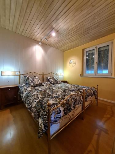 un grand lit dans une chambre avec un plafond en bois dans l'établissement Les Chouchous du Ried 1, à Saasenheim