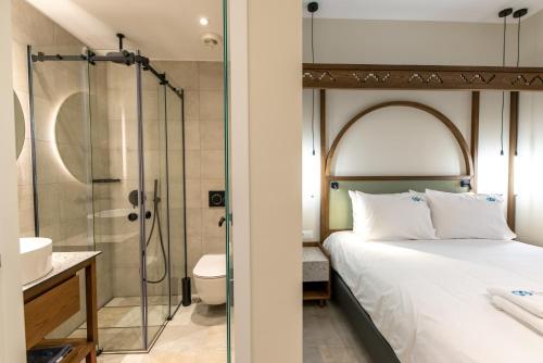 een slaapkamer met een douche en een bed en een badkamer bij El Greco Hotel in Chania