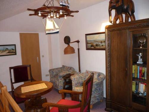 een woonkamer met een bank, een tafel en een stoel bij Fewo De luette Moew_KOC in Ostseebad Karlshagen