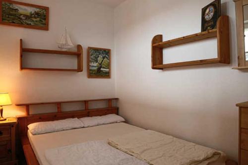 a bedroom with a bed and shelves on the wall at Fewo De luette Moew_KOC in Ostseebad Karlshagen