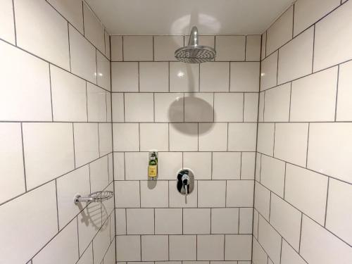 a bathroom with a shower with white tiles at traumHaff Historischer Kahnschifferhof mit Kamin, liebevoll restauriert in Vogelsang