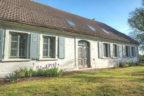 a white house with green windows and purple flowers at traumHaff Historischer Kahnschifferhof mit Kamin, liebevoll restauriert in Vogelsang