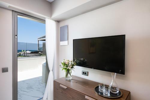 a living room with a large flat screen tv at Porto Platanias Beach Luxury Selection - Adults Only in Plataniás