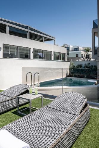 two beds sitting on the grass in front of a building at Porto Platanias Beach Luxury Selection - Adults Only in Plataniás