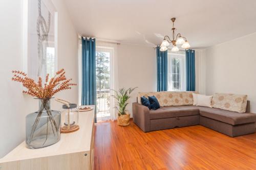 una sala de estar con un sofá y una mesa en Flatbook Apartamenty - Port Stegna z Parkingiem, en Stegna