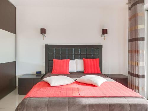 - une chambre avec un lit rouge et 2 oreillers rouges dans l'établissement Apartment Les Pins D'Alep by Interhome, au Cannet