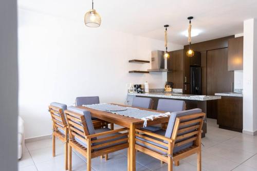 a kitchen and dining room with a wooden table and chairs at Familiar Departamento Cerca de la Playa in Mazatlán