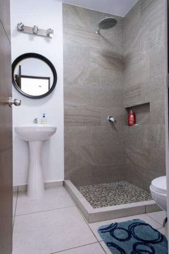 a bathroom with a shower and a sink at Familiar Departamento Cerca de la Playa in Mazatlán