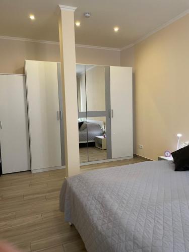 - une chambre avec un lit et un grand miroir dans l'établissement 2Raum-Apartment Leznew, à Leipzig