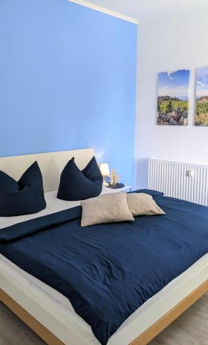 a bed with blue sheets and pillows in a room at Goethes liebste Betten - stilvolle Ferienwohnungen im historischen Fachwerkhaus in Wernigerode - Parkplatz, Smart-TV, W-Lan in Wernigerode