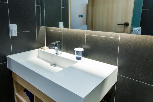 a bathroom with a white sink and a mirror at Hotel bridge Seogwipo in Seogwipo