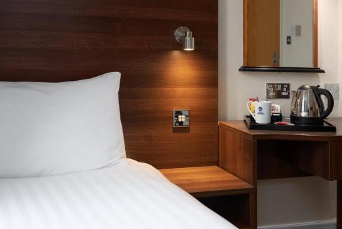 a bedroom with a bed and a wooden headboard at Best Western Carlton Hotel in Blackpool