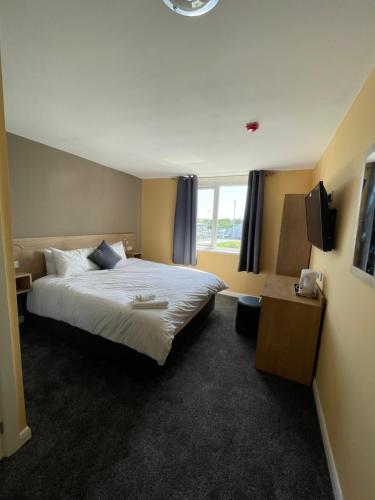 a hotel room with a large bed and a window at Tinapa Suites in Manchester