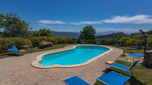 a swimming pool with blue chairs and a patio at PODERE SAN ANSANO 14&2, Emma Villas in Paganico