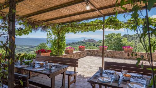 a table and benches on a patio with a view at PODERE SAN ANSANO 14&2, Emma Villas in Paganico