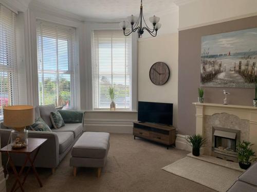 a living room with a couch and a fireplace at Bougainvillea in Ventnor