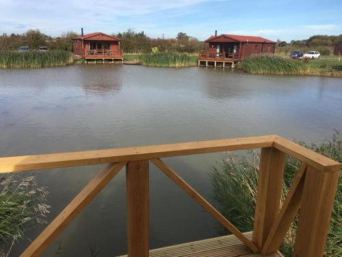 a bridge over a river with two houses on it at Lakeside Fishing Lodges in Boston