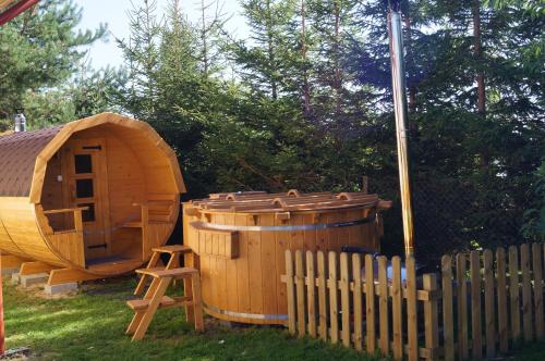 a wooden tub and a sauna next to a fence at Villa Amber in Sarbinowo