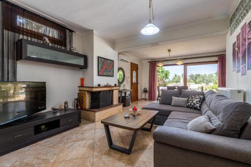a living room with a couch and a fireplace at Selia Villa Pefkochori in Pefkochori
