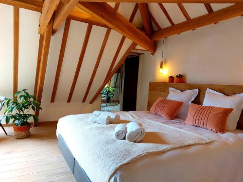 een slaapkamer met een groot bed en handdoeken bij Les Suites de Petit Bomal in Durbuy