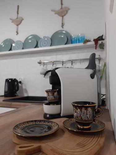 a coffee maker and two cups on a table at Capitals Residence in Oświęcim