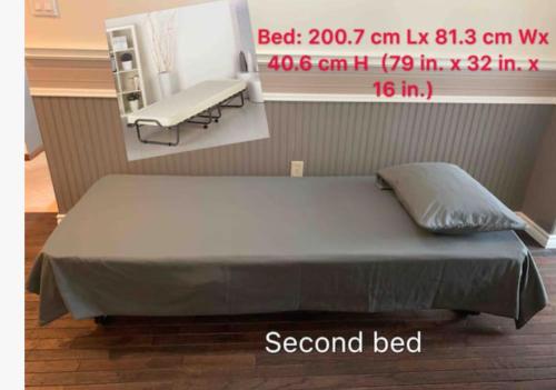 a bed in a room with a bench next to it at Chez Nous in Cornwall