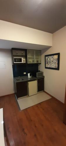 Habitación vacía con cocina con fogones y microondas. en VMA Suites- Civico en San Juan