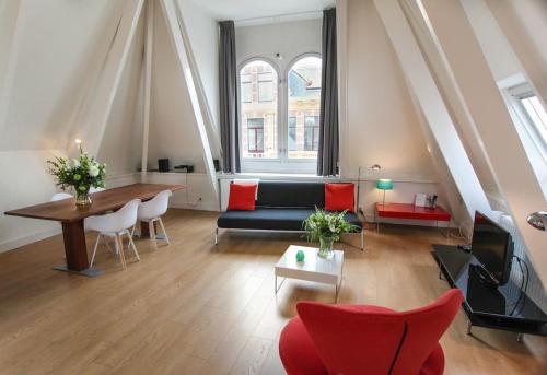 een woonkamer met een bank en een tafel bij Loft 6 kingsize apartment 2-4persons with great kitchen in Groningen