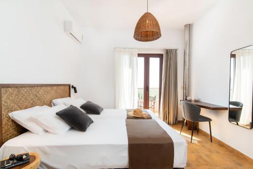 ファラサルナにあるVilla Tramontoのベッド、デスク、窓が備わるホテルルームです。