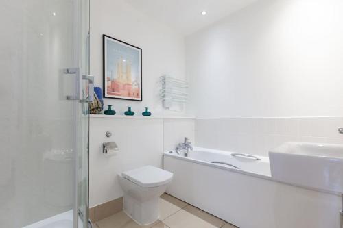 Baño blanco con aseo y lavamanos en Oxfordshire Living - The Tolkien Apartment - Oxford en Oxford