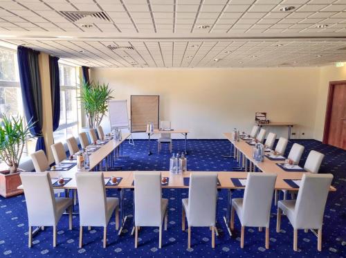 a large conference room with tables and chairs at CAREA Residenz Hotel Harzhöhe in Hahnenklee-Bockswiese