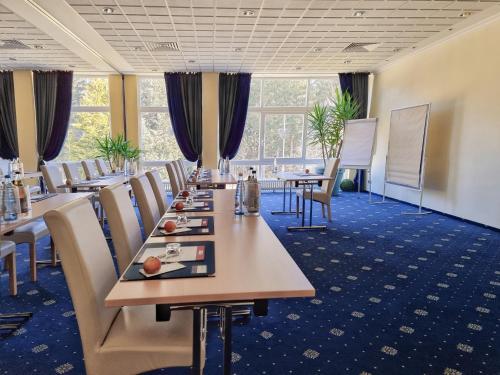 a conference room with long tables and chairs at CAREA Residenz Hotel Harzhöhe in Hahnenklee-Bockswiese