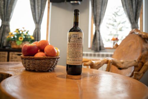 House Proctor في Stoykite: زجاجة من النبيذ موضوعة على طاولة مع سلة من الفواكه