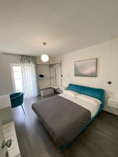 a bedroom with a large bed with a blue headboard at Casa Lombardi in Santa Maria di Castellabate
