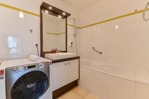 une salle de bain avec une machine à laver et un lavabo dans l'établissement Appartement Glamour, à Paris