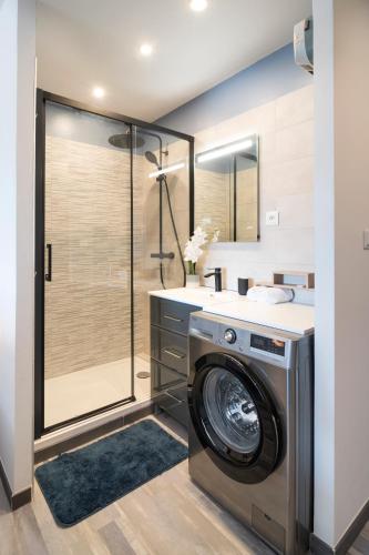 une machine à laver dans une salle de bain avec douche dans l'établissement Appartement Village Naturiste Irresistible, au Cap d'Agde
