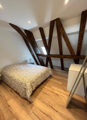 - une chambre dotée de poutres apparentes et d'un lit dans l'établissement Le Gutenberg, à Strasbourg