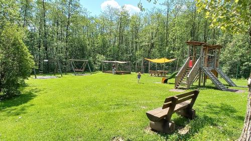 a park with a playground with a slide and a bench at MONA Haus KMB Seeblick Appartement am Ossiacher See mit direktem Seezugang, Hallenbad in Bodensdorf