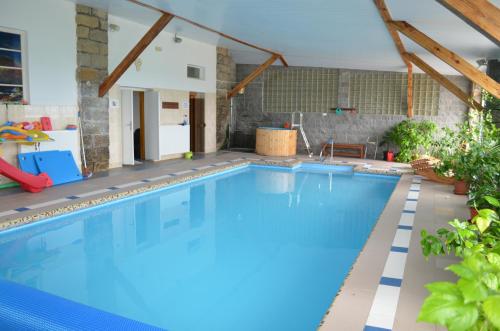a swimming pool with blue water in a house at Famozclub in Bakov nad Jizerou