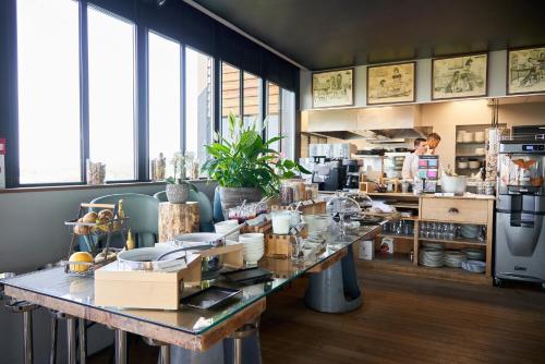 - une cuisine avec une grande table et de la vaisselle dans l'établissement L'Ermitage Hôtel Cuisine-À-Manger, à Saint-Cyr-au-Mont-dʼOr