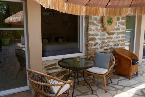 un patio avec une table, des chaises et un lit dans l'établissement Manoir de Chantemerle, à Sainte-Fortunade