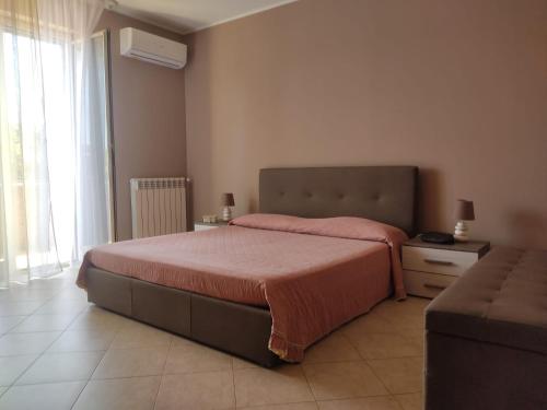 a bedroom with a large bed and a window at Casa Vacanza - Sole e Azzurro - in Fiumefreddo di Sicilia