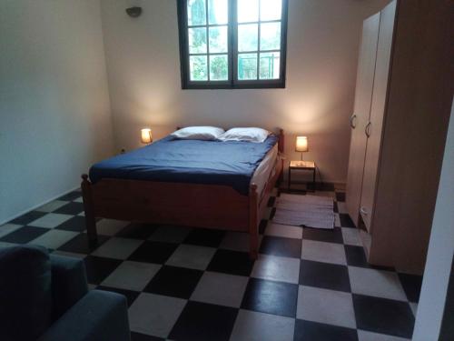 a bedroom with a bed and a checkered floor at Source AUGER in Gruchet-le-Valasse