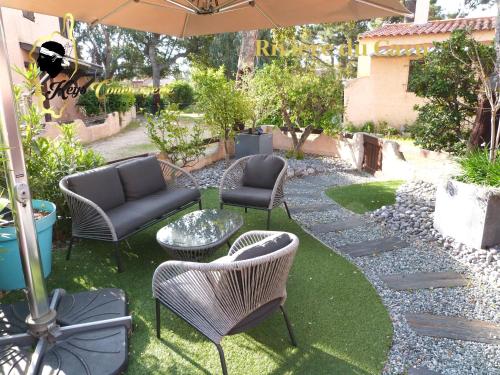 une terrasse avec des chaises, des tables et un parasol dans l'établissement Maison de Plage à pied San Cipriano 5 pers, à Lecci