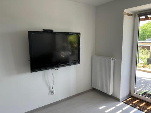a flat screen tv hanging on a white wall at Apartament Połaniecka 1B/2 in Zielona Góra