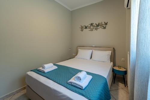 a bedroom with a bed with two towels on it at Bay View House in Petalidi