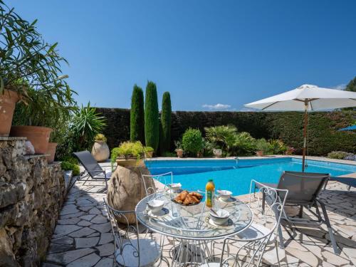 a patio with a table and chairs next to a pool at Villa Belvedere by Interhome in Mougins